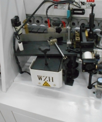 LTT-220PA Магазин подачи кромочного материала, включает в себя приводной подающий игольчатый ролик, специальное устройство для работы со шпоном (отводчик) и гильотину для предварительной обрезки кромки 