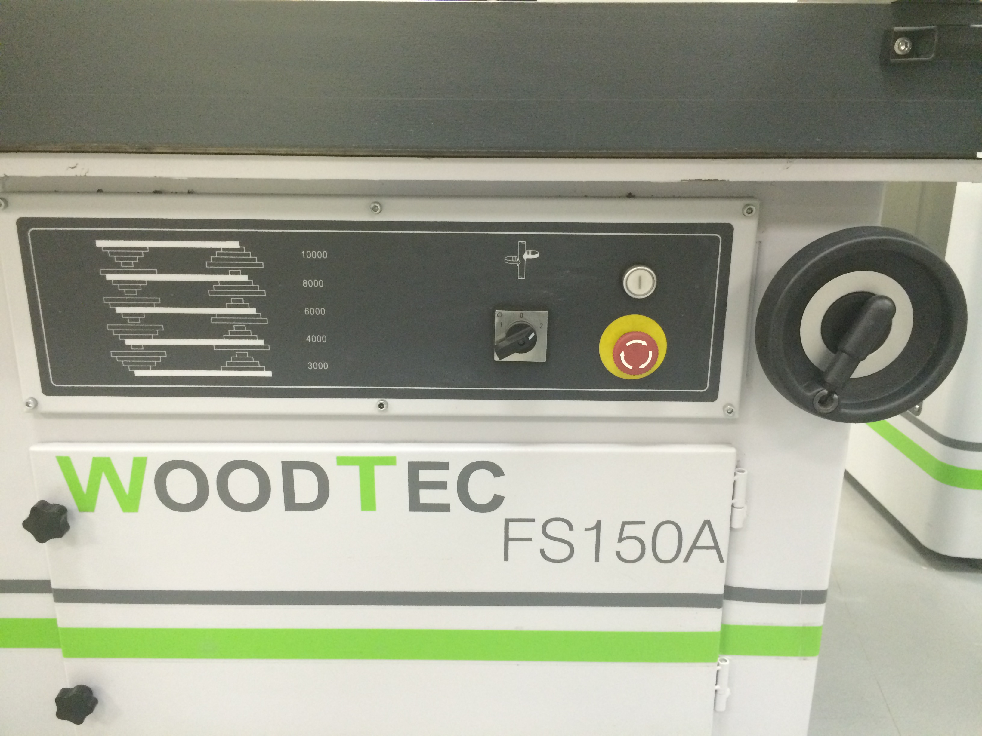 WoodTec FS 150 A  Панель управления 
 
 На передней панели станка расположен маховик подъема/опускания шпинделя, а также переключатель направления вращения шпинделя – реверс и кнопки включения и выключения  
 
